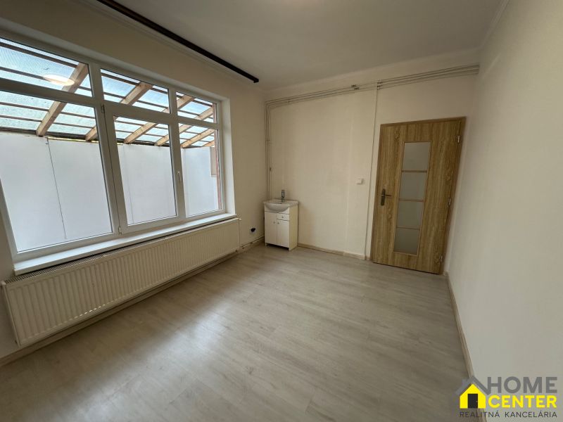 A bright room in a 3-room apartment with a window, a sink, and a floor with a wooden decor.