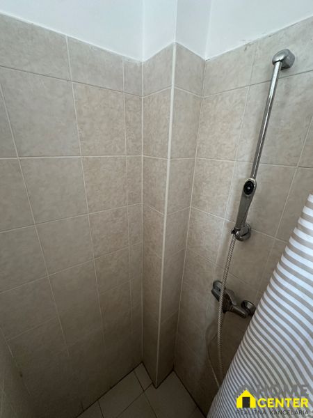 Shower corner with light tiles in a 3-room apartment.