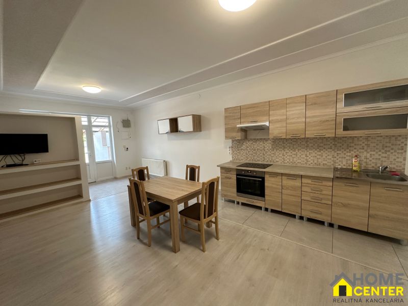A kitchen with wooden decor in a 3-room apartment with a dining table.