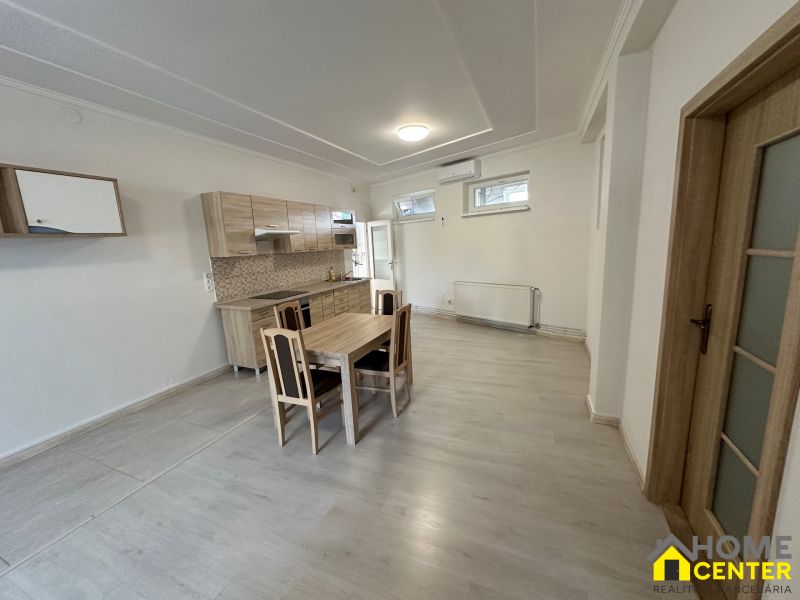 A kitchen in a 3-room apartment with a dining table and a floor with a wood decor.