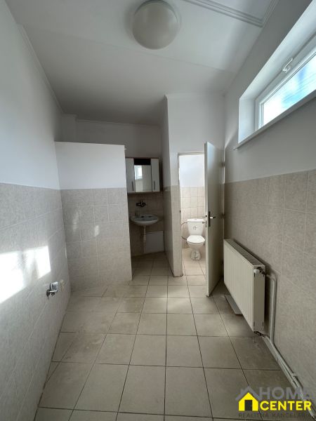 A hallway with light tiles and a view of the toilet in a 3-room apartment.