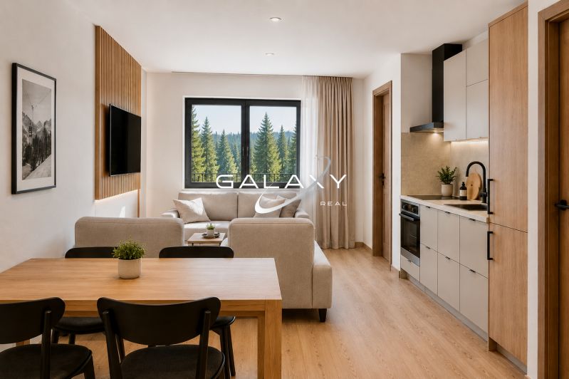 A bright interior of a holiday apartment with a wood-decor floor, a sofa, and a kitchenette.
