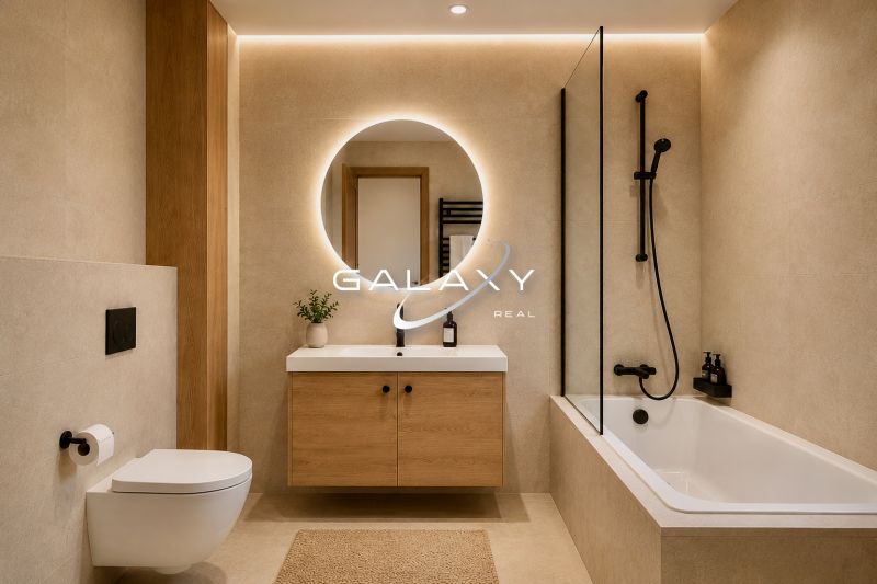 Bathroom in a holiday apartment with a wooden decor floor and a large mirror.