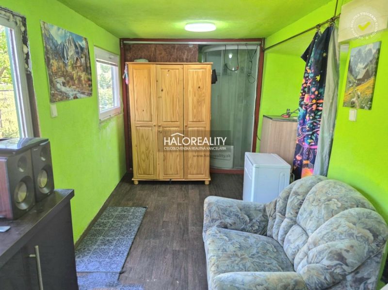 Interior in Gardens with a sofa, wardrobe, washing machine, and wooden decor flooring.