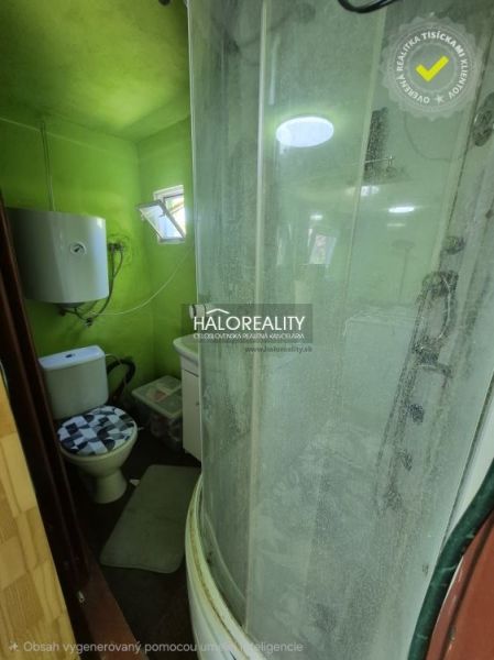 A small bathroom in the Gardens with a toilet, shower, and green walls.