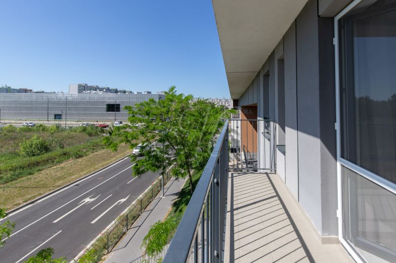 The balcony of the apartment on Zuzany Chalupovej Street in Bratislava, with a view of the road and the building.
