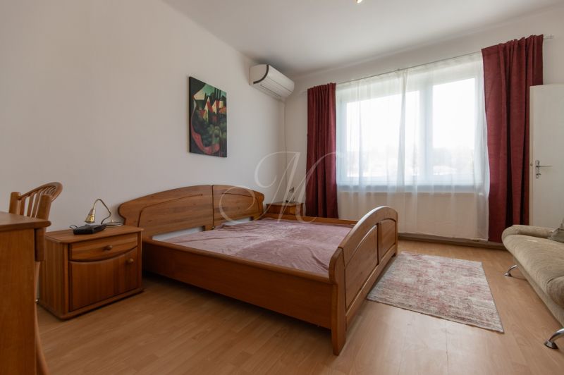 A bedroom with a wooden bed, nightstand, and floor with a wooden decor.