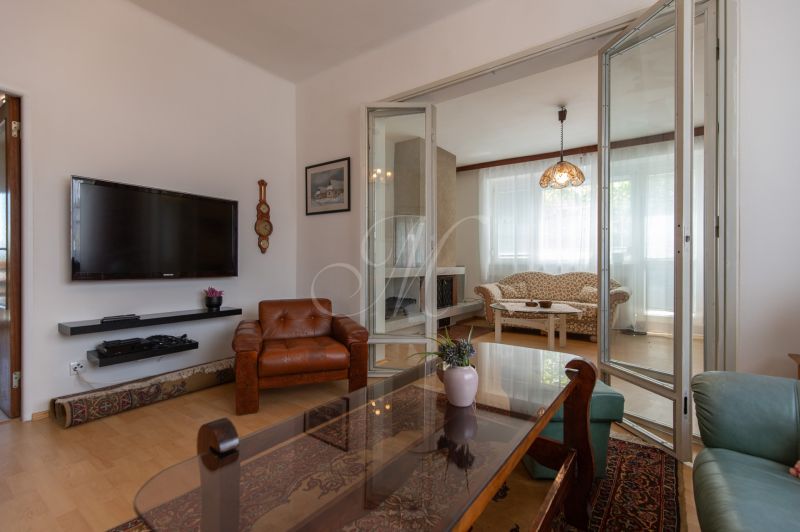 A living room in a 3-room apartment with leather sofas and a TV on the wall.