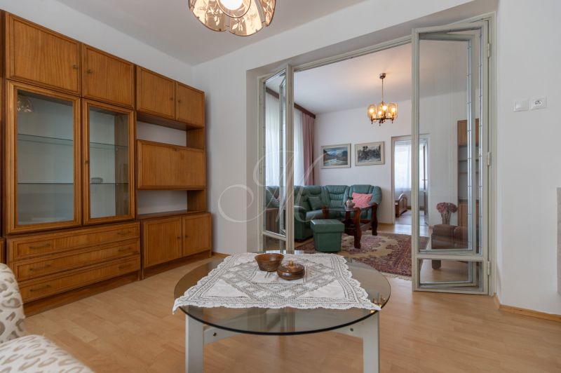 Living room in a 3-room apartment with a green sofa and furniture with a wooden decor.