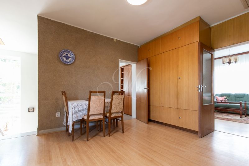 Dining area in a 3-room apartment with a wood-patterned floor and built-in wardrobes.