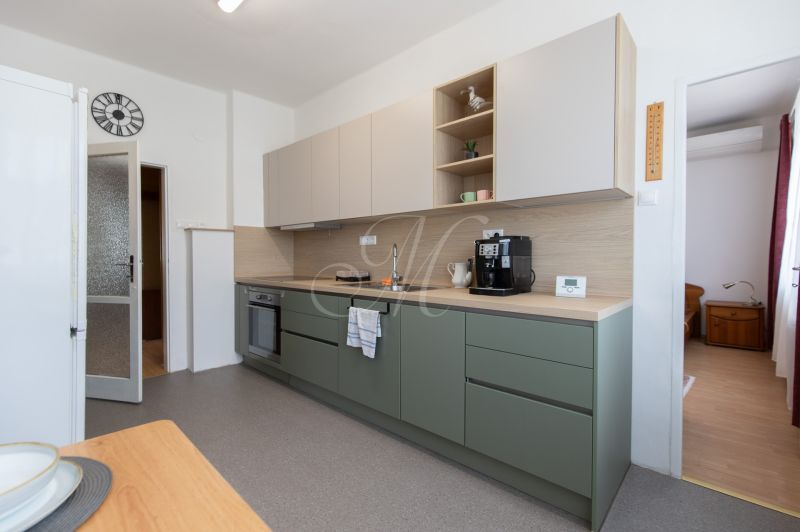 A kitchen in a 3-room apartment with a modern kitchen unit and a coffee maker.