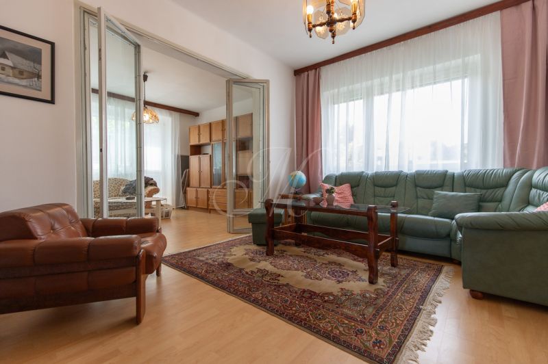 Living room in a 3-room apartment with a wooden decor floor and a folding wall.