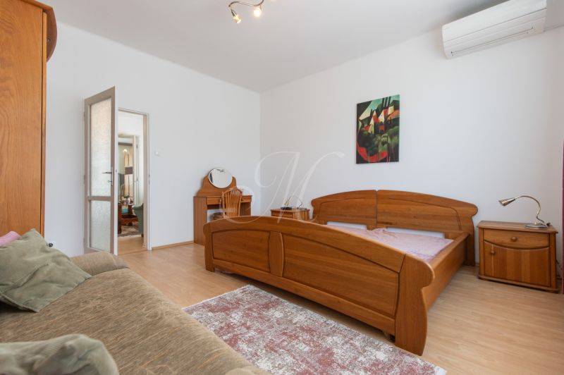 A bedroom in a 3-room apartment with wooden furniture and a floor with a wood decor.