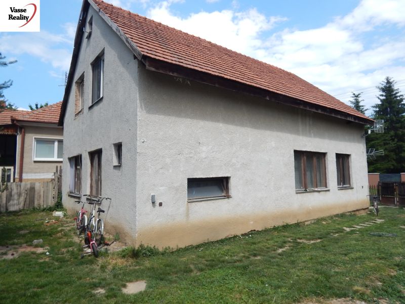A family house in Strekov with a brick roof and two bicycles by the wall.