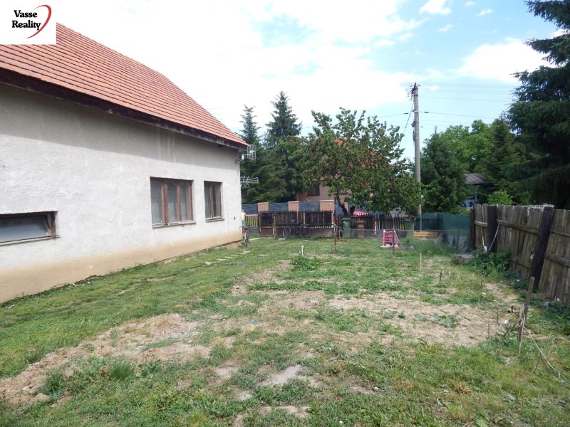 A family house in Strekov with a yard and garden. Surroundings with a fence and vegetation.