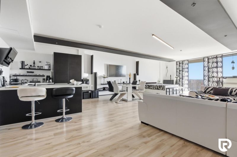 Spacious living area in a 2-room apartment with wood-patterned flooring.