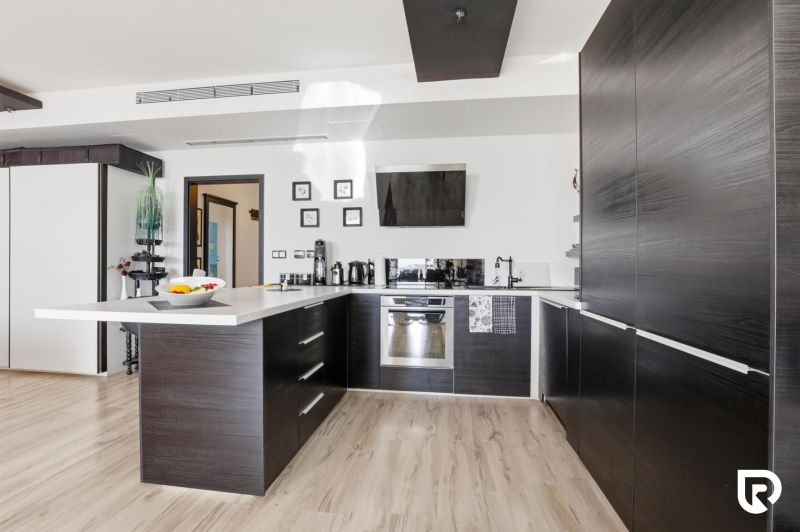 A kitchen in a 2-room apartment with a wood-patterned floor and modern furnishings.