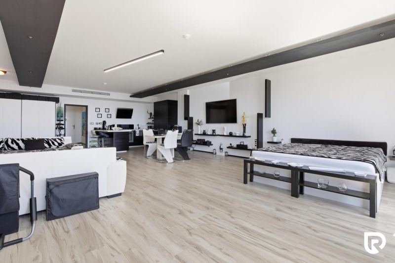 A spacious living room with wood-patterned flooring in a two-room apartment.
