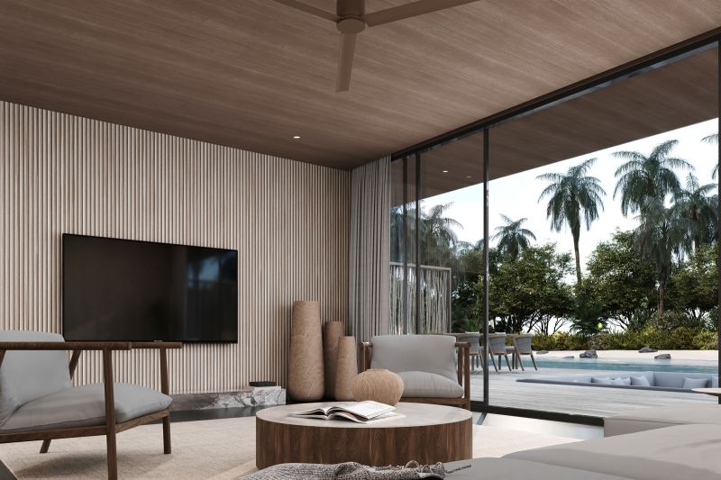 Villa with seating area, television, and views of palm trees and pool.