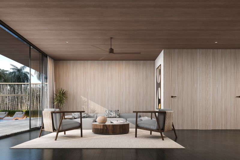 Bright living room in a villa with sofas, ceiling fan, and wood-patterned flooring.