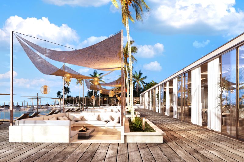 In Nungwi, you will see a beach terrace with seating, palm trees, and a wooden decor floor.