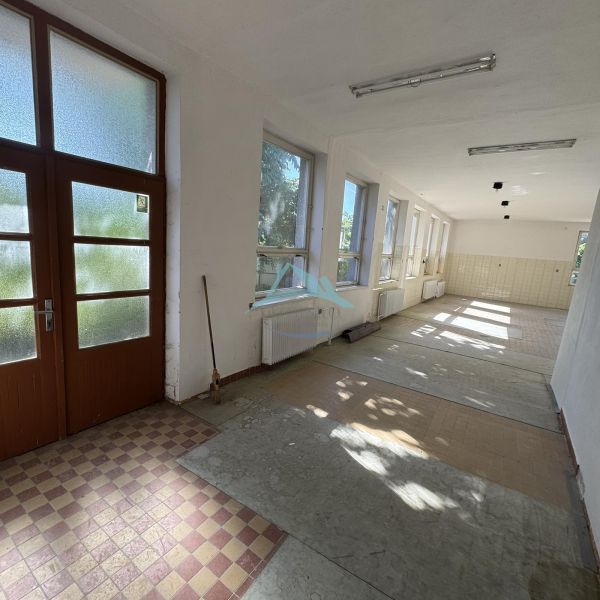 Spacious commercial spaces with light fixtures and large windows.