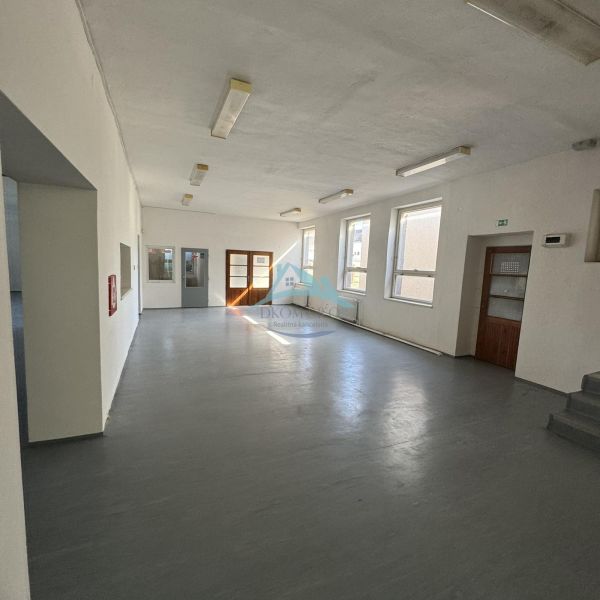 Commercial premises with multiple windows and a gray floor without decor.