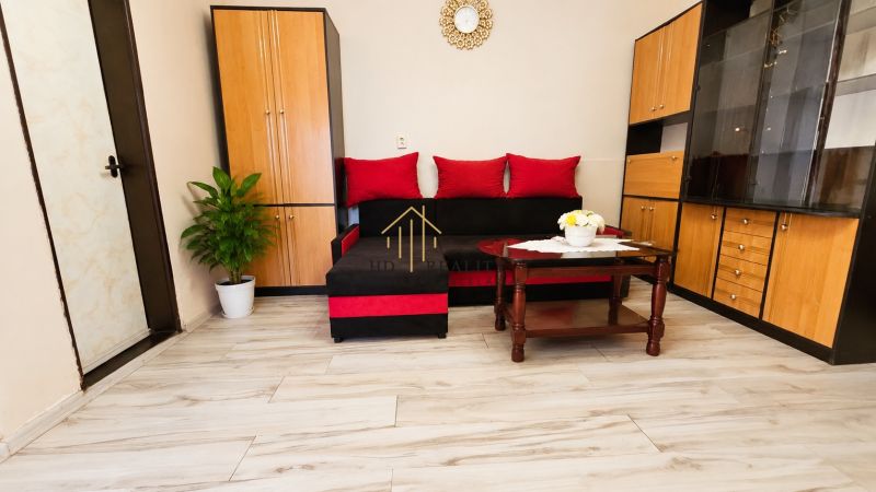 Living room in a family house with a sofa, furniture, and wooden decor flooring.