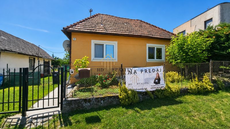 A family house for sale in Demandice surrounded by a garden and fencing.