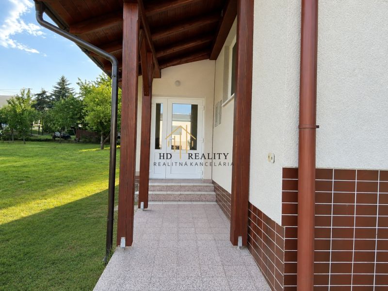 Entrance to a family house in Sebechleby with a lawn and a covered terrace.