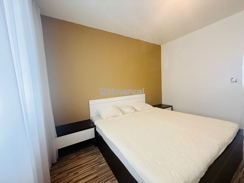 Bedroom in a 3-room apartment with a bed and a wooden decor floor.
