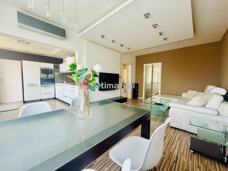 Living room with kitchen in a three-room apartment with a wooden decor floor.