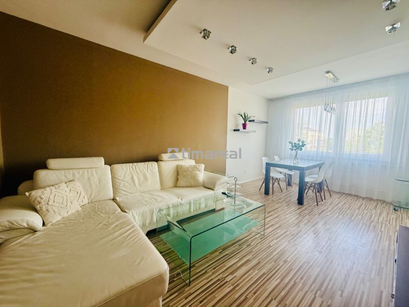 Living room in a 3-room apartment with a wood-patterned floor and modern furniture.