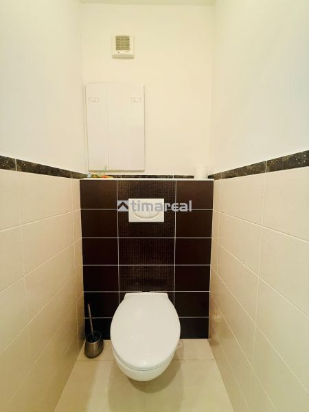 A toilet in a 3-room apartment with contrasting tiles.