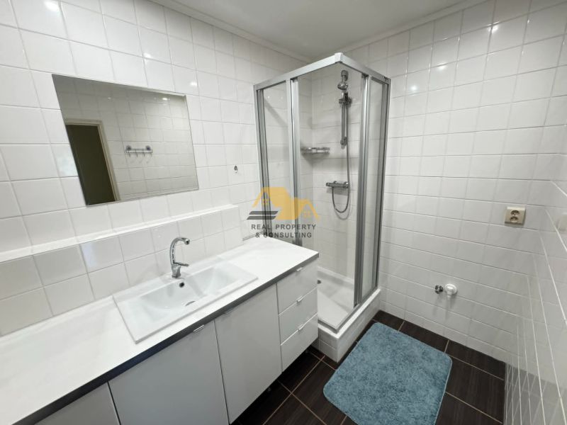 Bathroom in a 3-room apartment with a shower and white tiles.