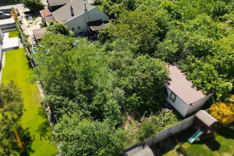 Plots - housing in Dunajská Lužná with garden greenery and a small building.
