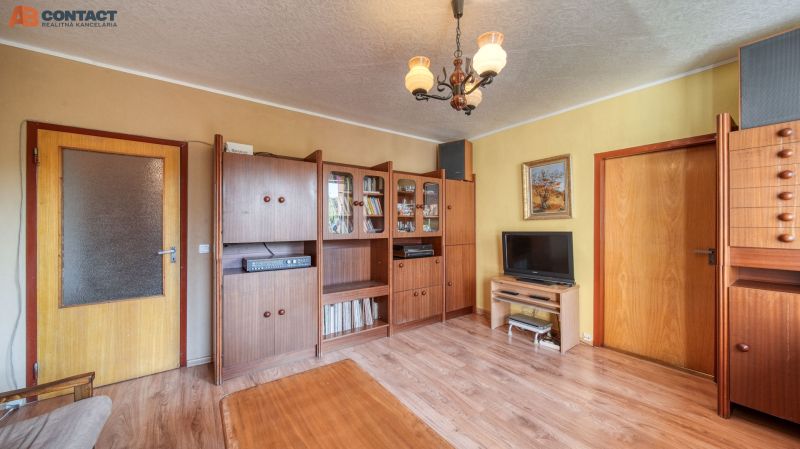 Living room with antique furniture, wooden decor flooring, in a 4-room apartment.