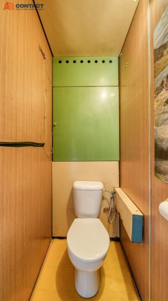 A toilet with a wooden decor floor in a 4-room apartment.
