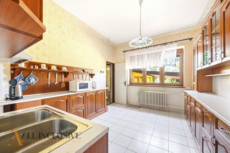 A kitchen with wooden decor and white tiles in a family house.