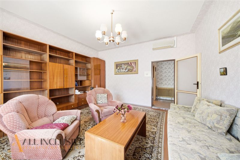 Living room in a family house with wooden decor furniture, carpet, and a sofa.