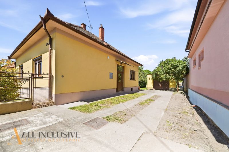 A family house in Dunajská Streda with a landscaped yard and a yellow facade.