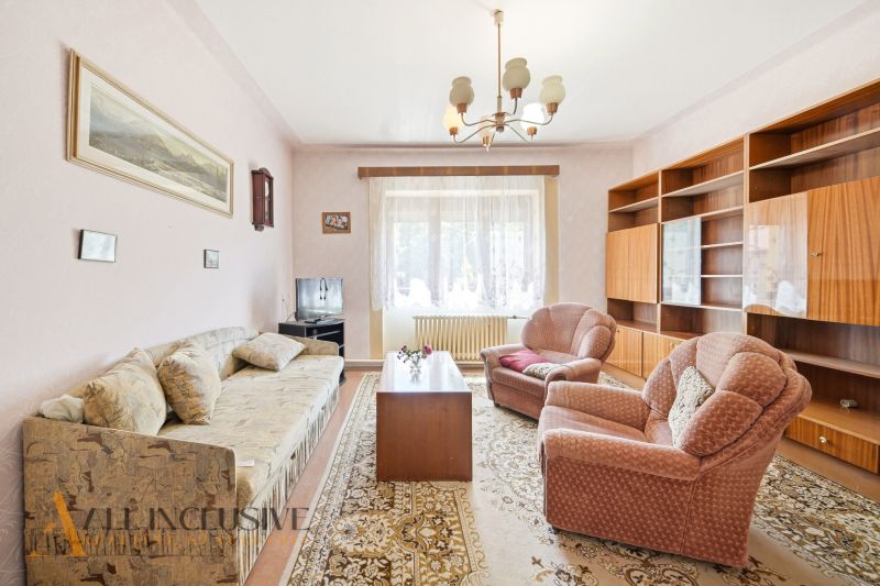 Living room in a family house with a sofa, armchairs, and wooden furniture.