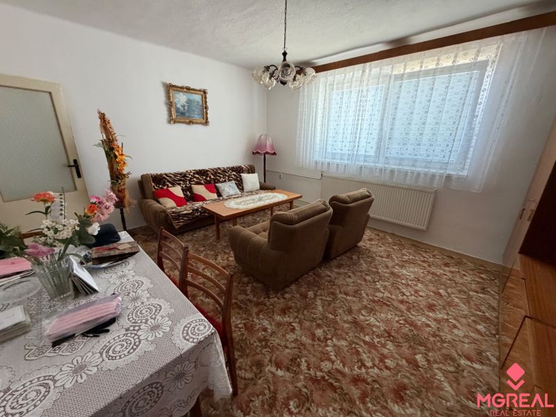Living room in a family house with floral decorations and plenty of textiles.
