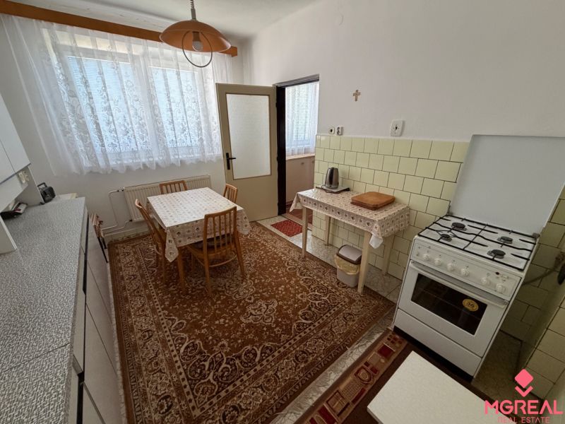 A kitchen in a family house with a dining table, a gas stove, and vintage decoration.