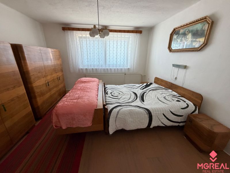 Bedroom in a family house with wooden cabinets and a bed on a wooden decor.