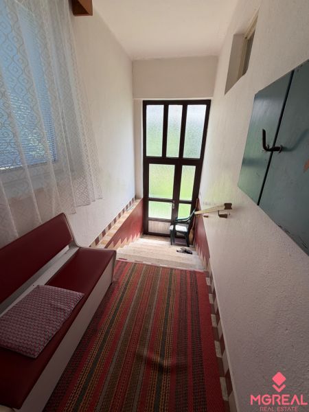 Staircase in a family house with a bench, carpet, and glass doors.