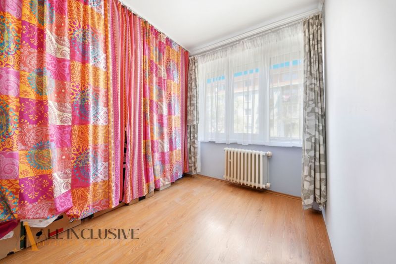 Colorful curtains and a wooden decor floor in a 3-room apartment.