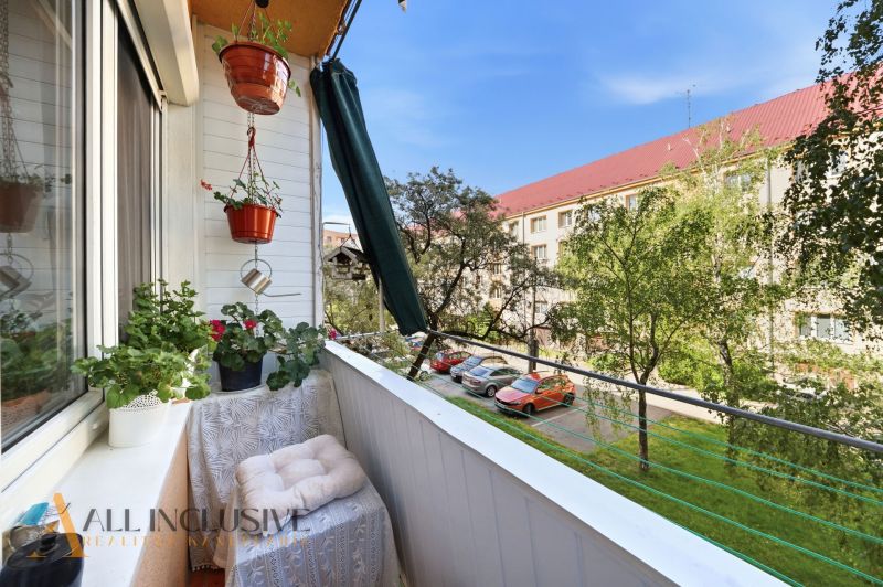 A balcony with flowers, a view of cars and trees on Kukučínova Street in Dunajská Streda.