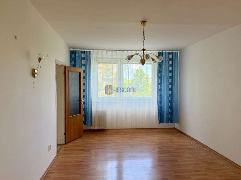 Living room with wood-patterned flooring, blue curtains, and a ceiling chandelier.