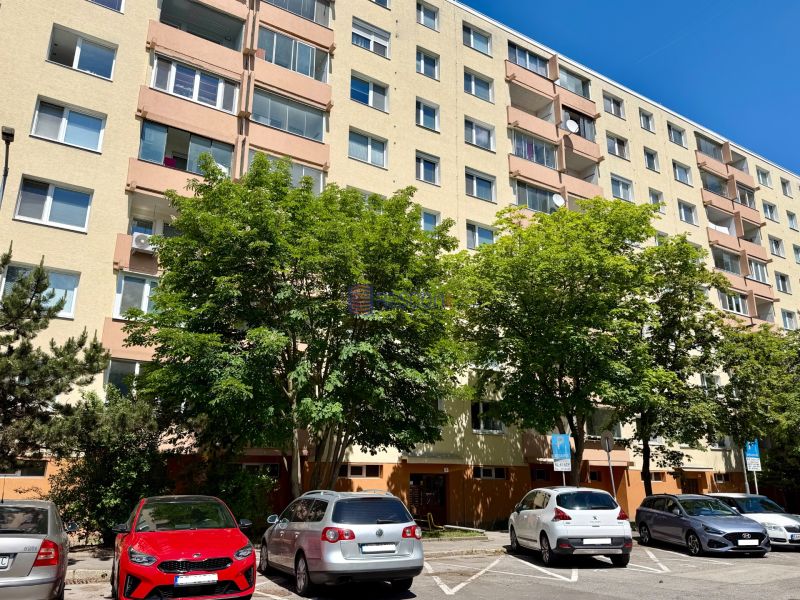 6-storey apartment building with trees and parked cars on Pri kríži in Bratislava.